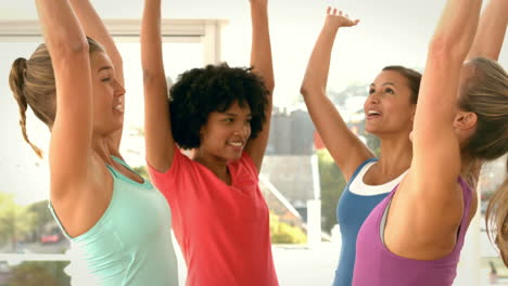 mujeres en forma apilando las manos juntas