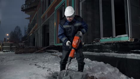 trabajador de la construcción usando un martillo aerodinámico por la noche
