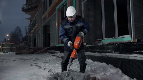 construction worker using a jackhammer at night