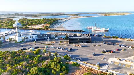 Aerial footage captures Queenscliff's harbor, lighthouses, and coastline under bright daylight, showcasing boats and surrounding greenery