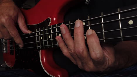 primer plano medio de los dedos tocando el bajo eléctrico mostrando el posicionamiento de la mano derecha