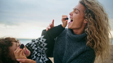 Niño-Feliz-Jugando-A-La-Madre-En-El-Primer-Plano-De-La-Playa-De-Otoño.-Familia-Alegre-Divirtiéndose