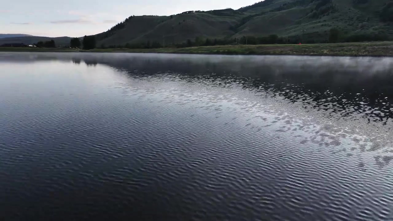 Tidlig morgen over en dampdækket sø i Colorado, lavt lys, skygger, luftbåren panorering.