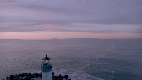 Beautiful-pre-sunrise-video-of-Santa-Cruz-harbor-lighthouse-with-bird-flying-through-shot-from-beginning