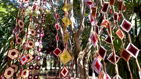 vibrant mobiles hanging among lush greenery