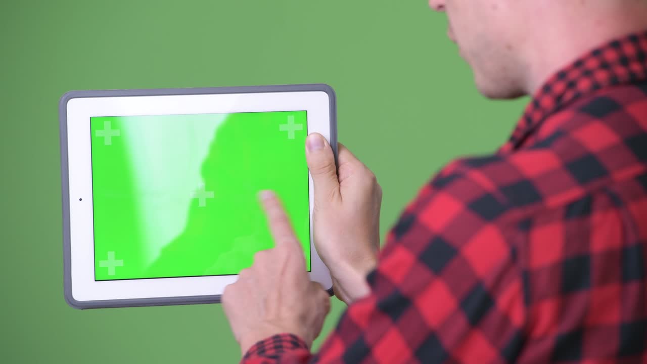 녹색 배경에 디지털 태블릿을 사용하는 젊은 스칸디나비아 사업가