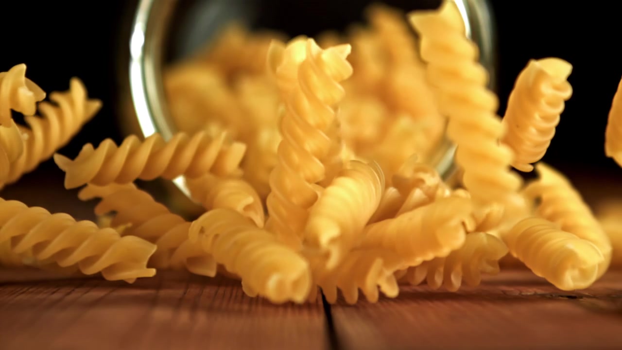 Slow Motion of Fusilli Pasta Falling on a Wooden Table