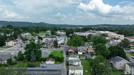 small historic town in american with old buildings, houses and garden. cars on street of neighborhood. colonial and victorian architecture style. aerial birds eye