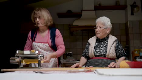 aged women cooking tortellini together in kitchen