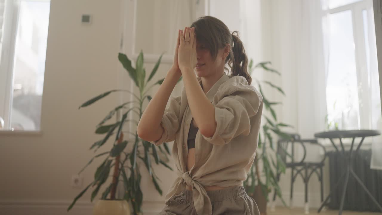 Женщина практикует йогу дома.