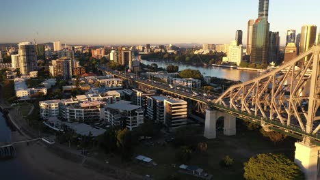 brisbane city sunrise beautiful aerial with cbd, brisbane river, buildings, story bridge and numerous cars on highway