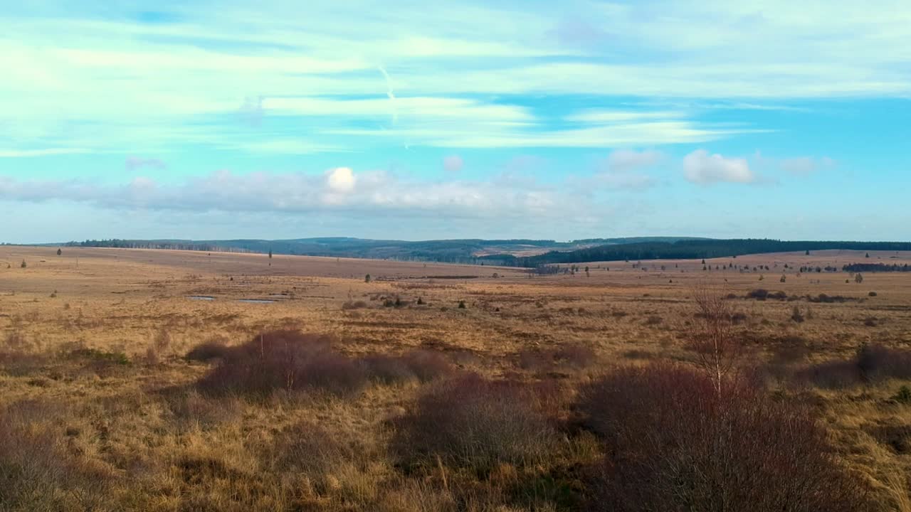 Aerial forward shot marshland valley clouds blue sky colorful landscape