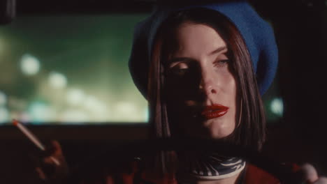 elegant woman smoking cigarette while driving at night in city