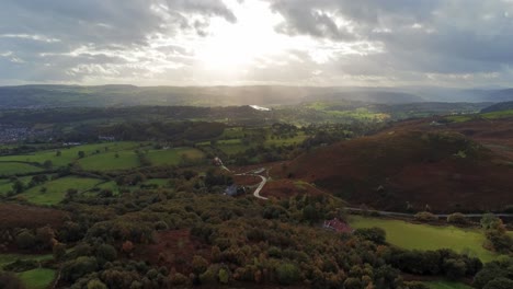 Sunrays-moving-across-rural-English-farmland-countryside-early-dawn-aerial-view-descending