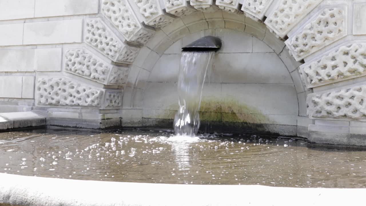 agua que fluye de una fuente de piedra
