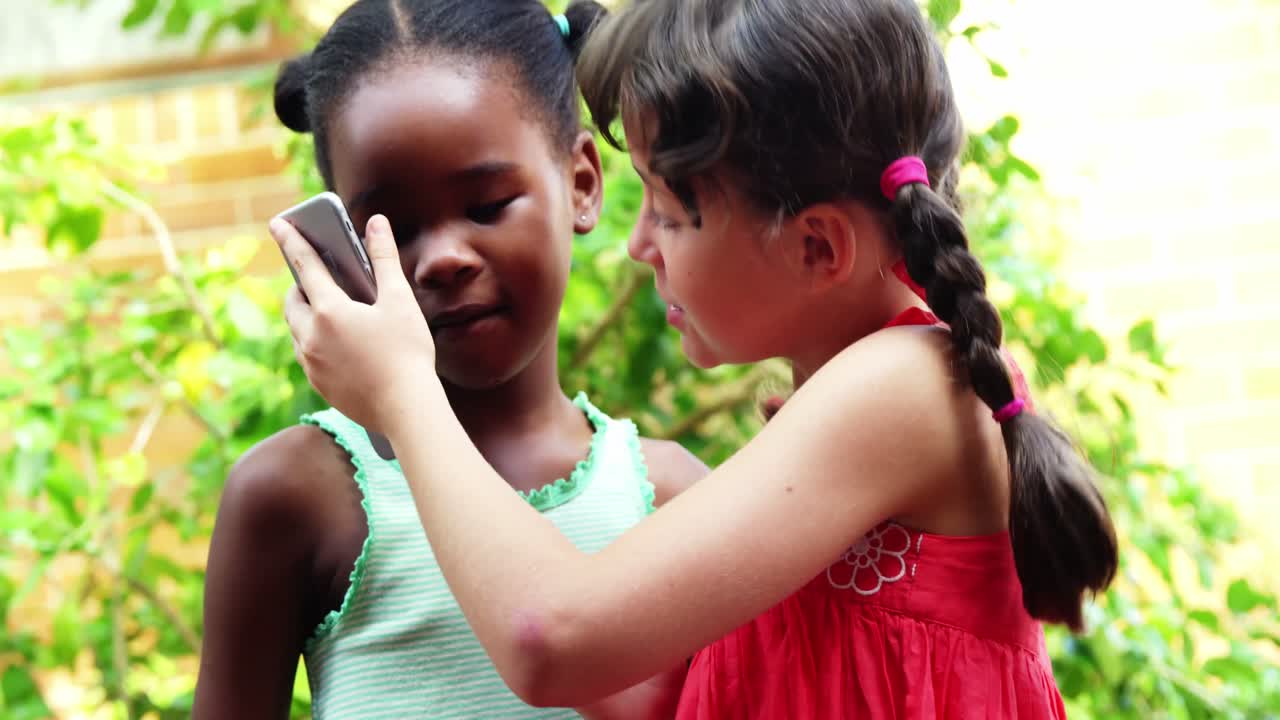 escolares que usan teléfonos móviles en el campus en la escuela