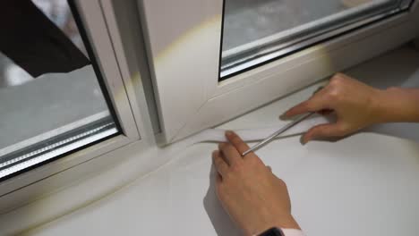 mujer instalando aislamiento de ventanas