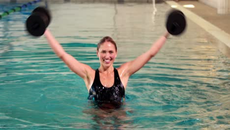 Fit-woman-doing-aqua-aerobics-in-the-pool-with-foam-dumbbells