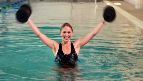 Mujer-En-Forma-Haciendo-Aeróbic-Acuático-En-La-Piscina-Con-Pesas-De-Espuma.