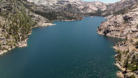 expansive aerial of a large high sierra lake in california surrounded by granite and pine trees