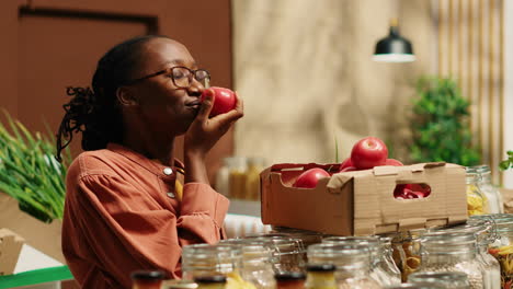 Vegan-woman-smelling-fresh-bio-tomatoes-from-market-crates