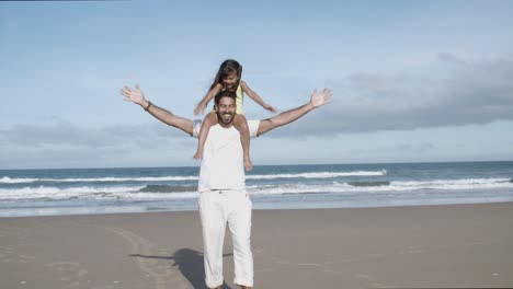 happy little daughter riding on fathers neck