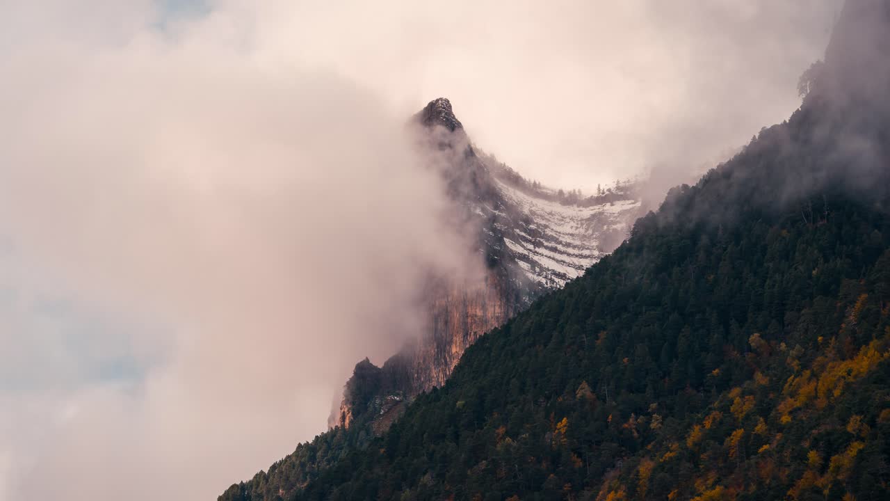 Ordesa national park valley tozal de mallo mountain on a cloudy and misty winter morning timelapse of clouds rolling over mountain peaks in fall autumn season
