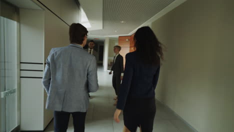 business people walking in an office corridor