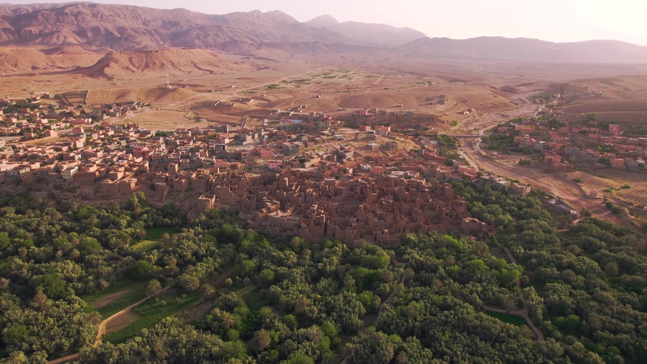 Tinghir in Draa-Tafilalet, Marocco, tra le catene dell'Alto Atlante e del Jbel Saghro, che mostra una transizione ecologica dalla vegetazione dell'oasi di Phoenix dactylifera a terreno arido e distretti urbani in espansione.