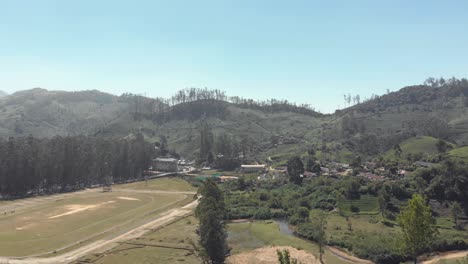 4K-Drohnenaufnahmen-Aus-Der-Luft,-Die-Die-Ländliche-Teeplantagenstadt-Munnar,-Indien,-Umgeben-Von-Einer-Wunderschönen-Tallandschaft-Der-Westlichen-Ghats-Bergkette,-Zeigen