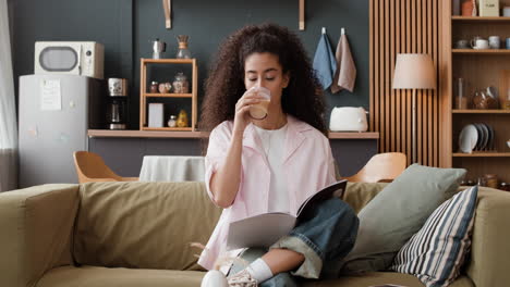 young woman relaxing and reading on a couch at home