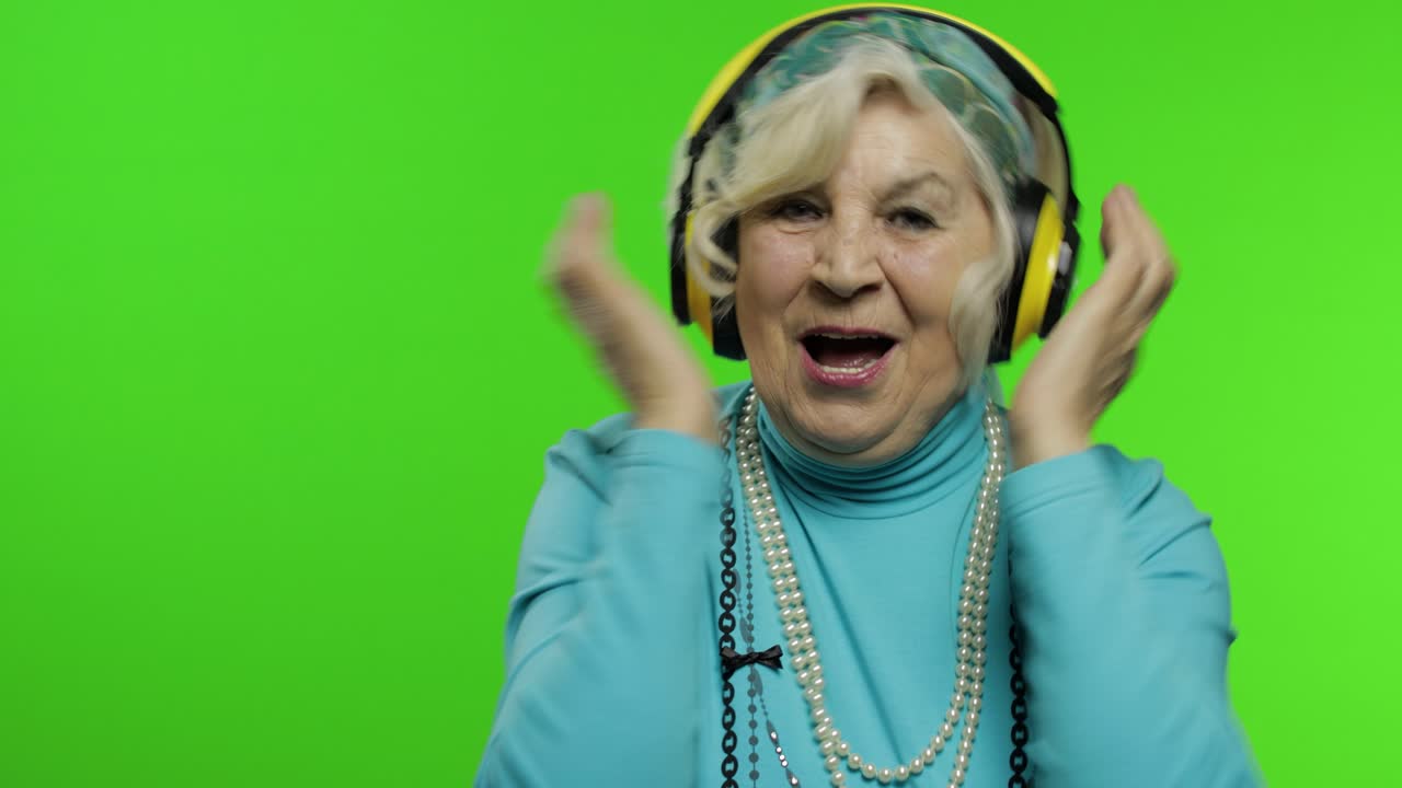 Nonna anziana. Donna caucasica. Balla, festeggia, ascolta musica. Chroma key.
