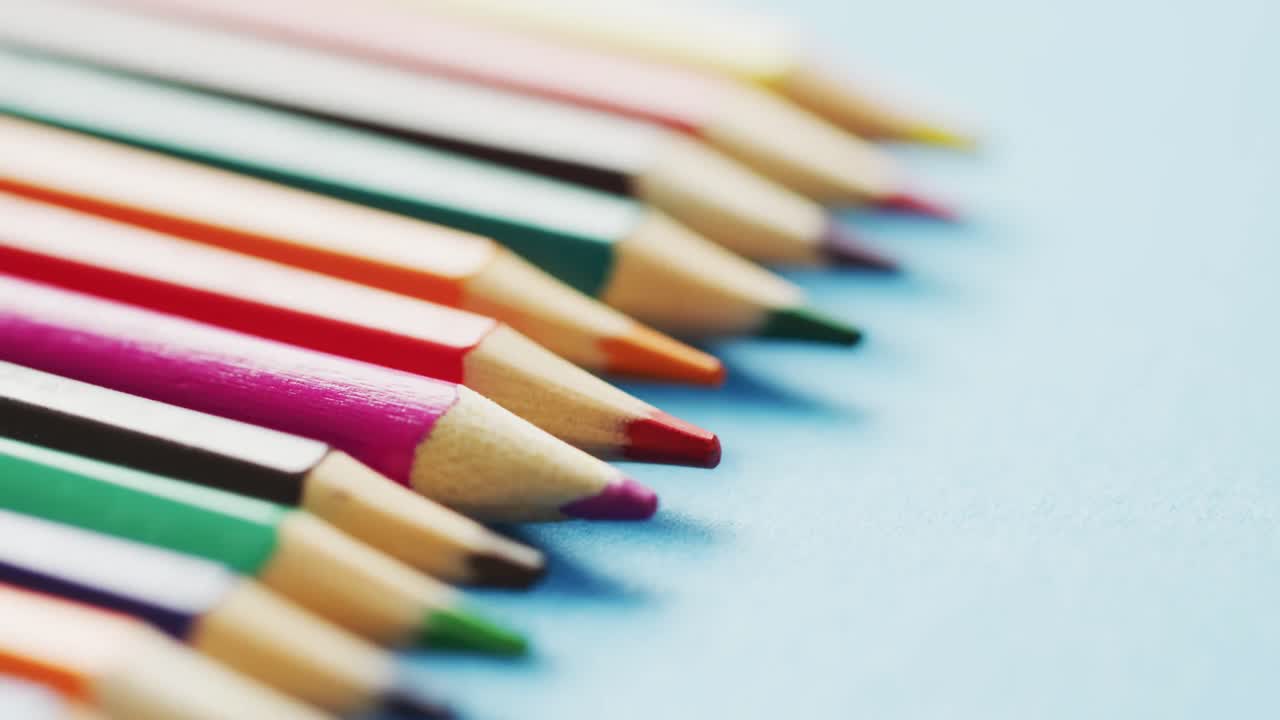 vídeo de la composición con lápices de colores en superficie azul claro