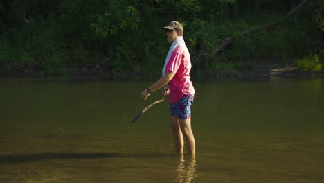 Man-Standing-In-Shallow-Water-Of-The-Lake---wide