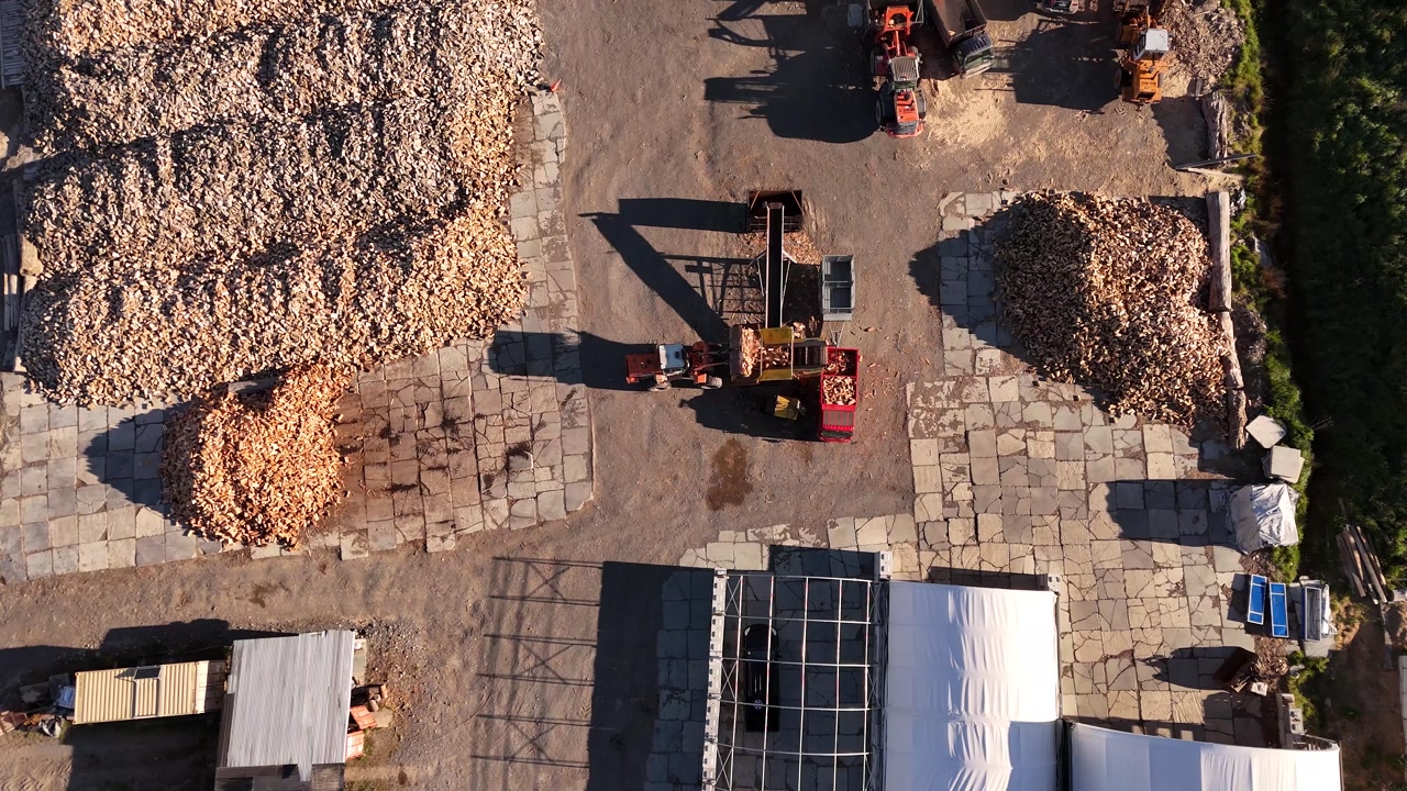 Top-down view of a timber harvesting company where machines and tractors process the wood.