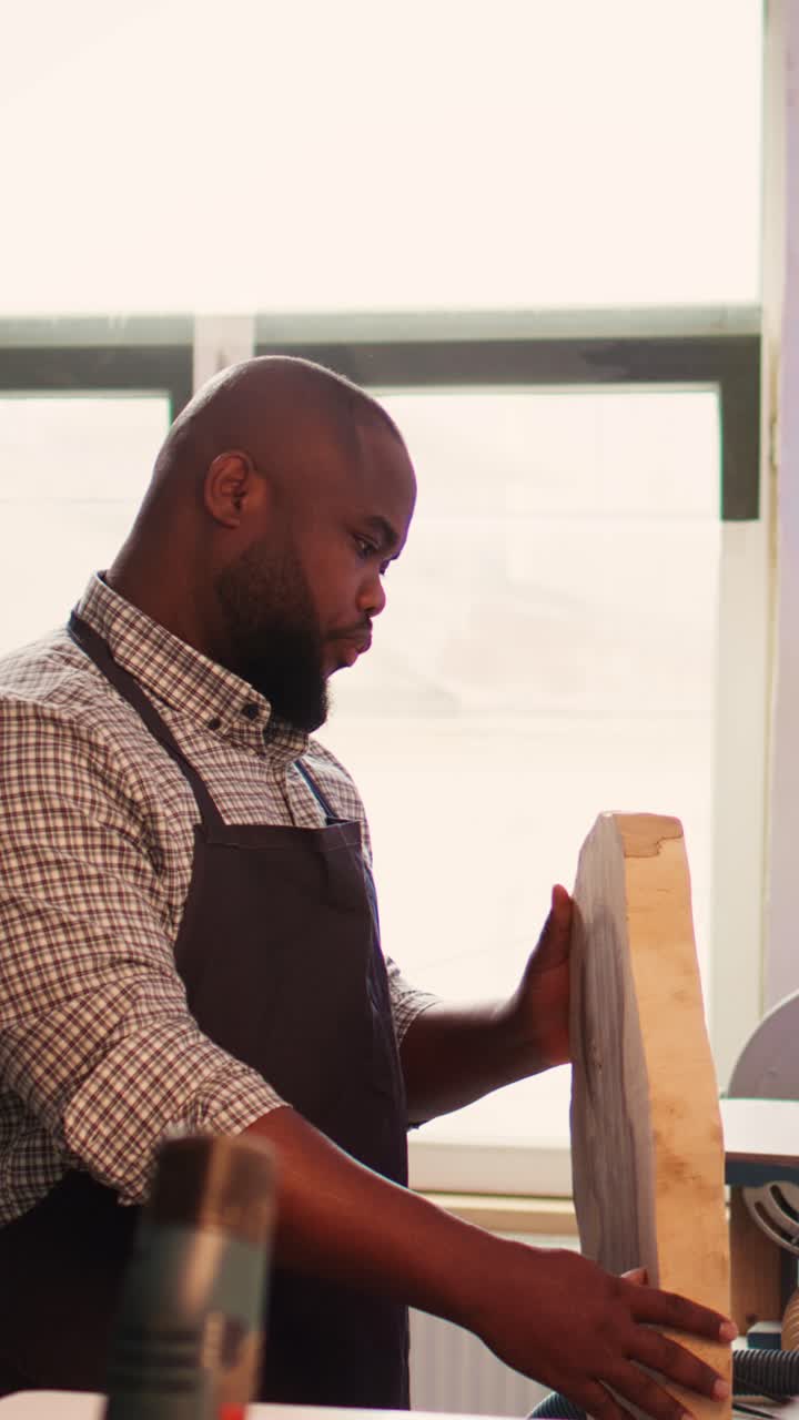African American Craftsman Examining Wood and Smiling