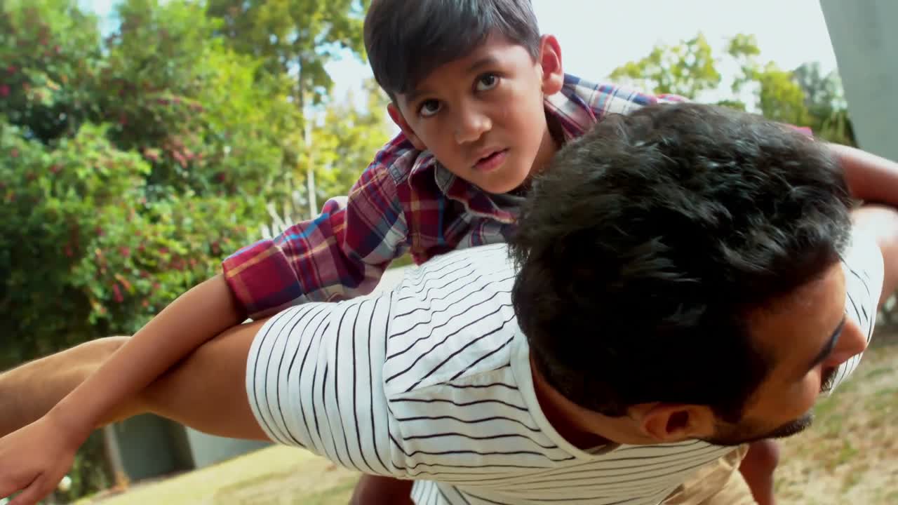 padre dando un paseo a hombros a su hijo