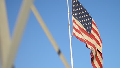 american flag flies behind metal bars