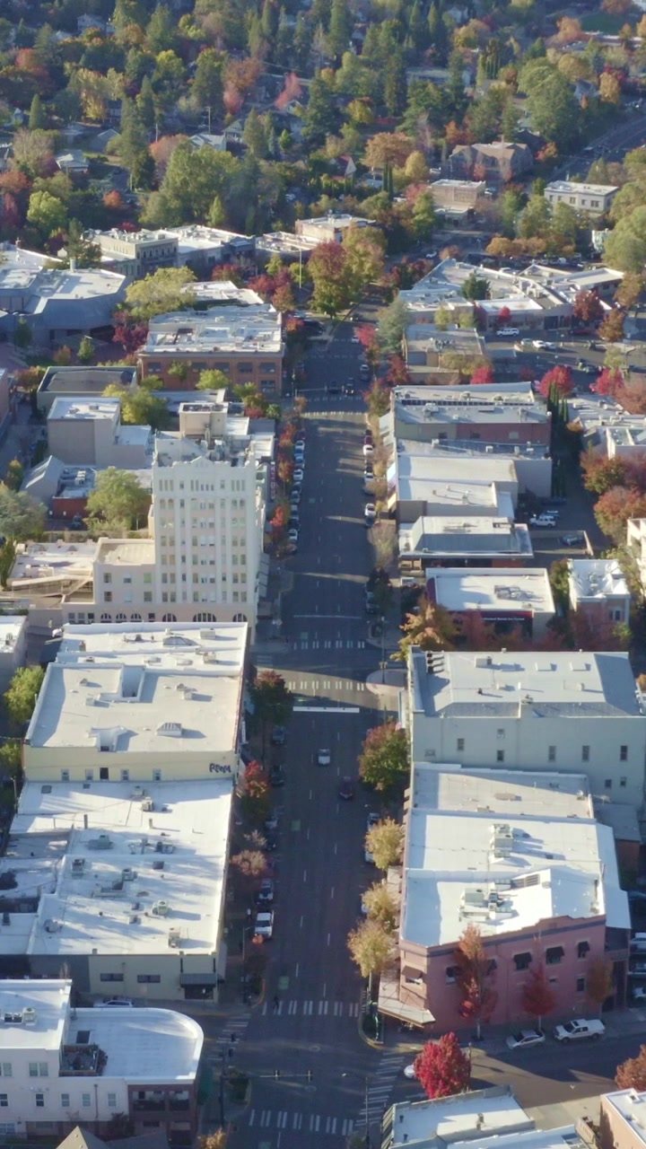 Droneoptagelse ovenfra, der ser lige ned ad Main Street i Ashland, panorerer fremad forbi Ashland Springs Hotel og efterårsfarvede træer, der omkranser den tomme gade nedenfor.