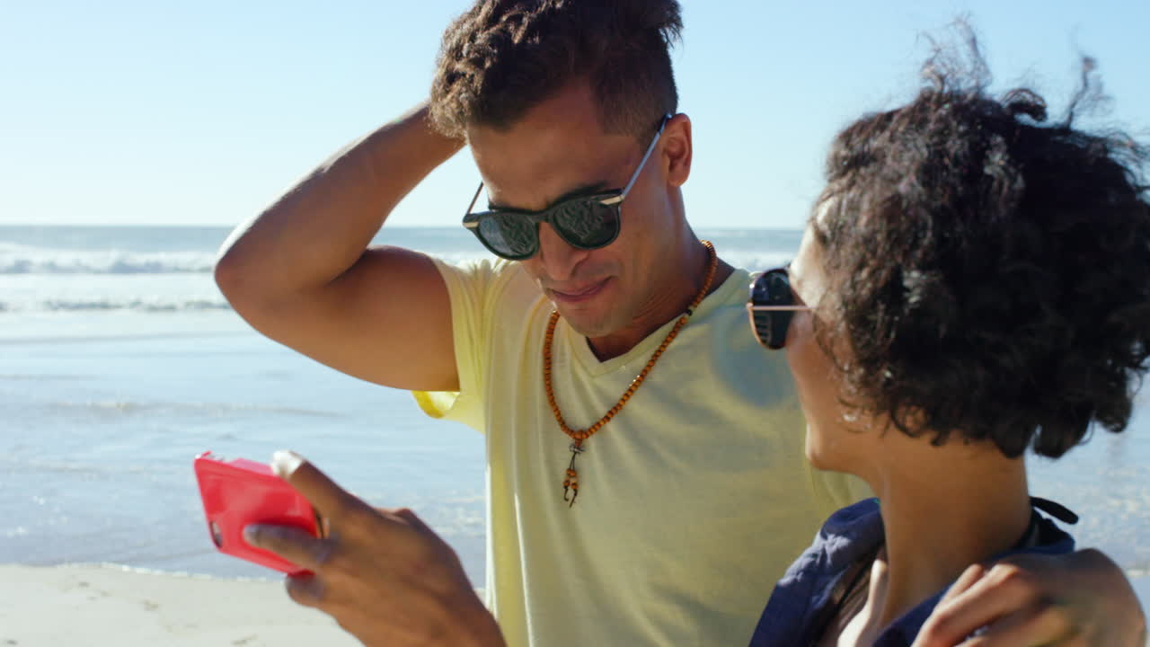 pareja tomando selfie en la playa