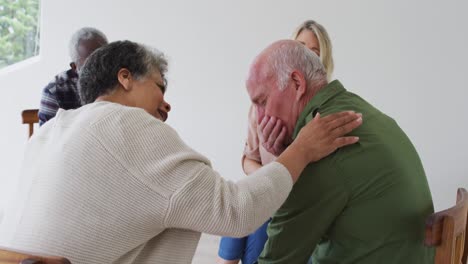 Two-diverse-senior-couples-sitting-in-circle-having-a-therapy-conversation-at-home