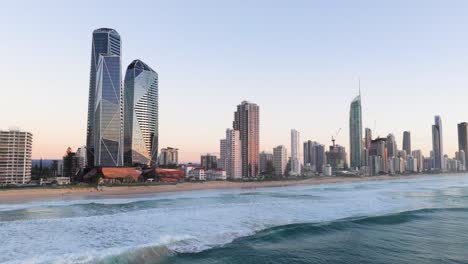 aerial view of gold coast's skyline at sunset with gentle ocean waves and vibrant cityscape