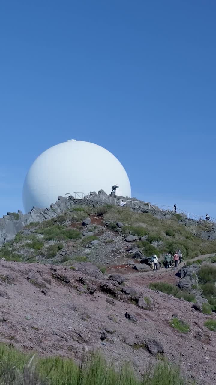 Grande Cúpula de Radar Branca em um Pico de Montanha Rochoso com Caminhantes