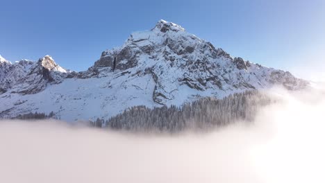 aerial view of fronalpstock in glarus, switzerland, with snowy peaks above clouds