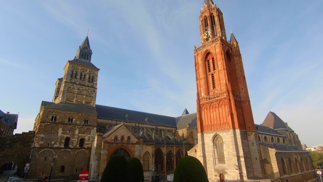 Dolly shot revealing Maastricht's famous twin churches, the Sint Servaasbasiliek and the Sint Janskerk, in daylight with blue sky