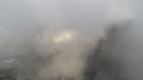 aerial shot tilt down to uk power station cooling towers smoke steam emissions at sunrise