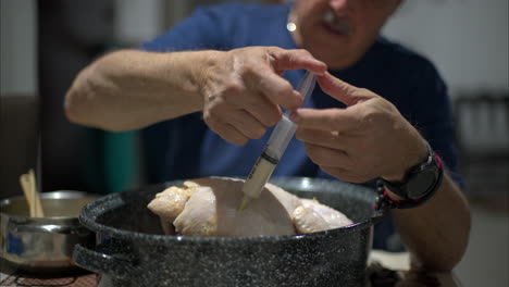 cerca de las manos de un hombre hispano inyectando un pavo crudo dentro de una olla para navidad, año nuevo, celebraciones de acción de gracias