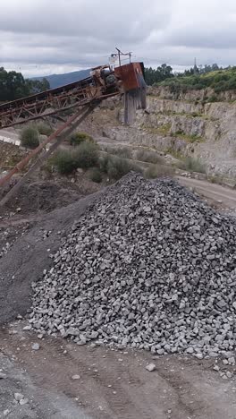 a quarry with piles of gravel and a conveyor belt system