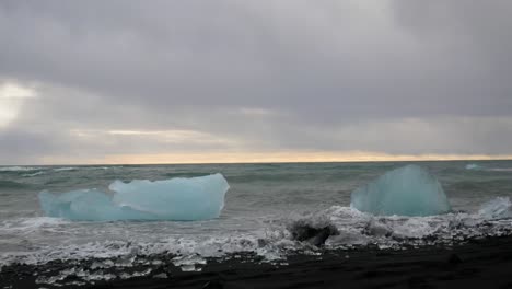 waves crashing over blue icebergs