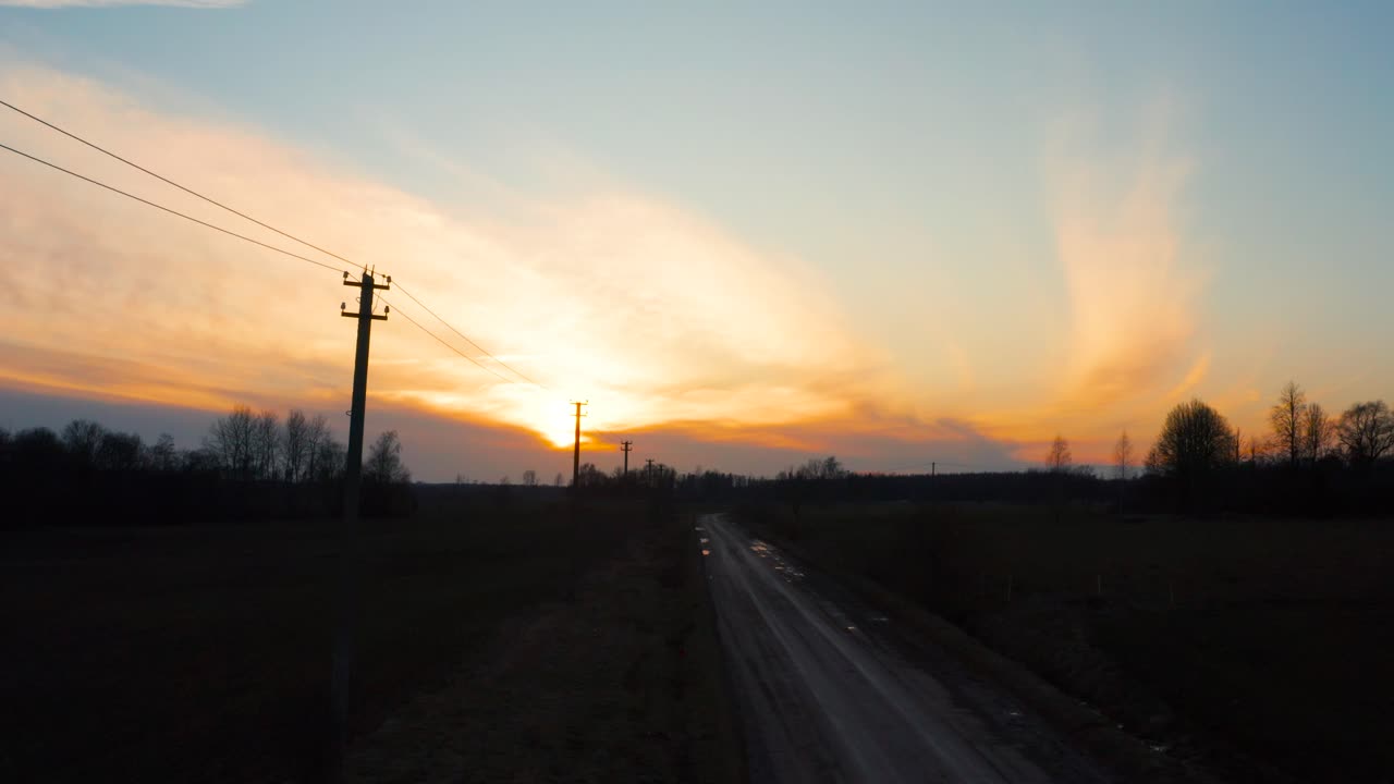 postes de líneas eléctricas y carretera de grava durante el atardecer de la hora dorada